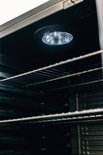 Close-up of the interior lighting and wire shelves of a refrigerator, highlighting the sleek and modern design.