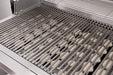 Close-up of a stainless steel grill interior showing thick grill grates and ceramic briquettes arranged underneath for heat distribution.