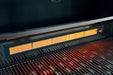 Interior view of a grill showing an active infrared burner glowing bright orange and heating the grill grates below.