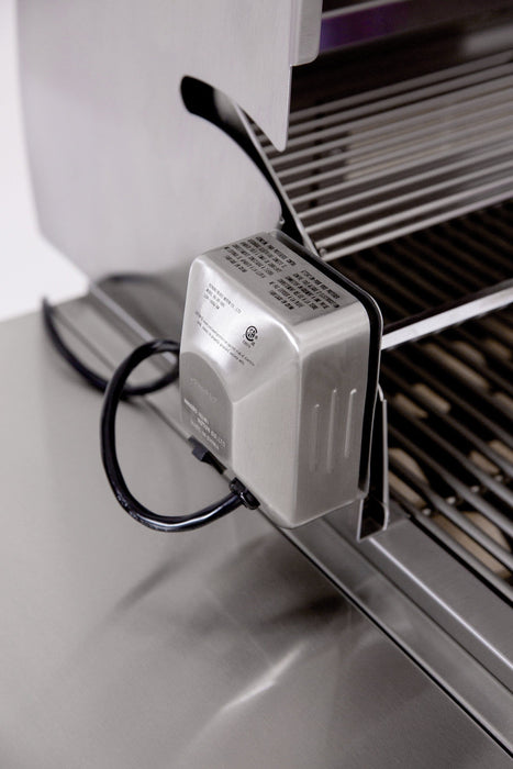 Close-up of a rotisserie motor attached to the side of a stainless steel grill, showing a connected power cord and grill grates.