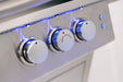 Close-up of three stainless steel control knobs on a grill, with blue LED lights illuminating the panel and a "Rear Burner" label.