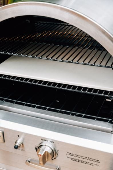 Stainless steel oven with open door showing multiple cooking racks and a stone baking surface, featuring a control knob and labels below.