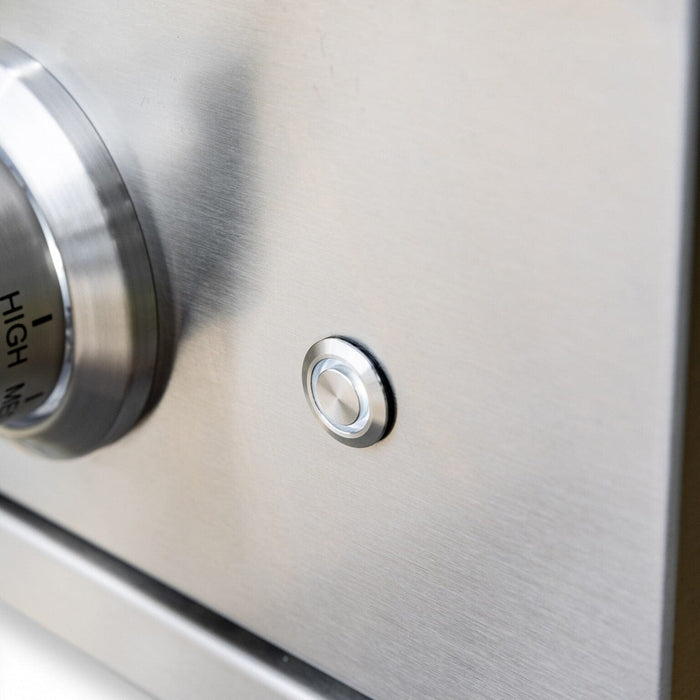 Close-up of stainless steel ignition button beside control knob on outdoor cooking appliance for easy burner start.