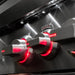 Close-up of stainless steel grill control knobs illuminated with red LED lighting on brushed metal panel.