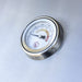 Close-up of stainless steel grill temperature gauge displaying heat levels for precise outdoor cooking control.
