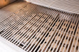 Close-up view of stainless steel grill grates, showing ceramic briquettes underneath for even heat distribution.