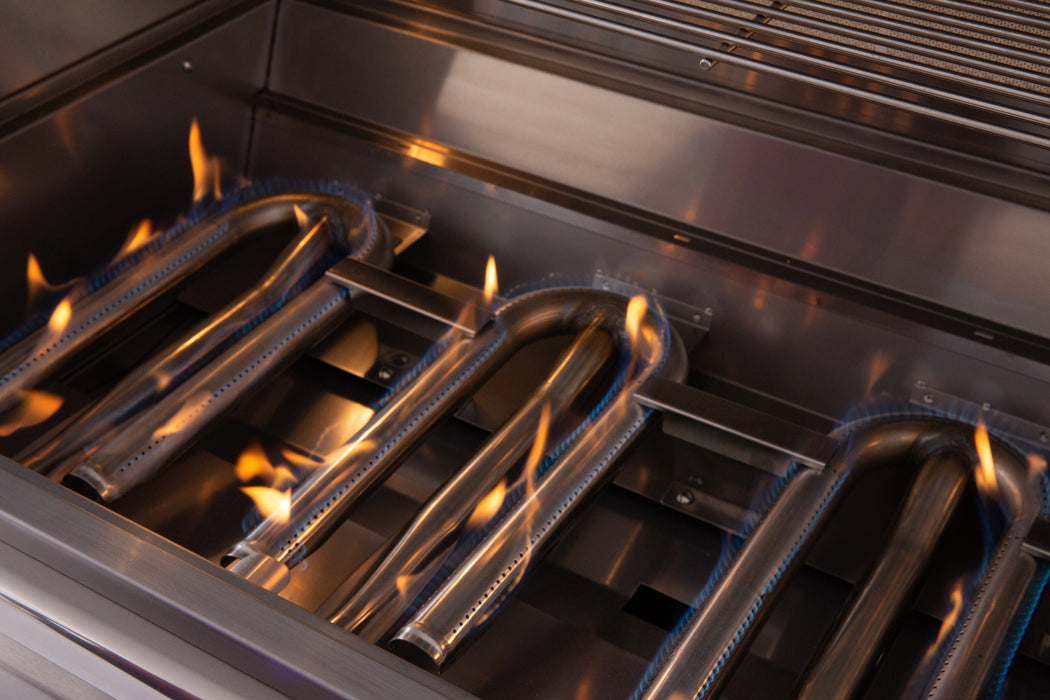 Close-up of a gas grill interior showing blue flames burning evenly across stainless steel tube burners.