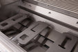 Close-up of a stainless steel grill interior showing unlit burners, grill racks, and heat distribution panels inside the cooking chamber.