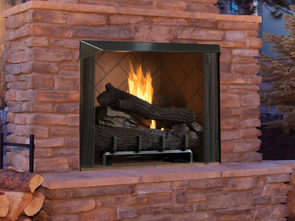 Rustic outdoor fireplace with a stacked stone design, glowing fire, and realistic log set, creating a warm and inviting ambiance.