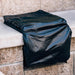 Protective black cover fitted over an American Made Grills Alturi built-in double side burner in an outdoor kitchen.