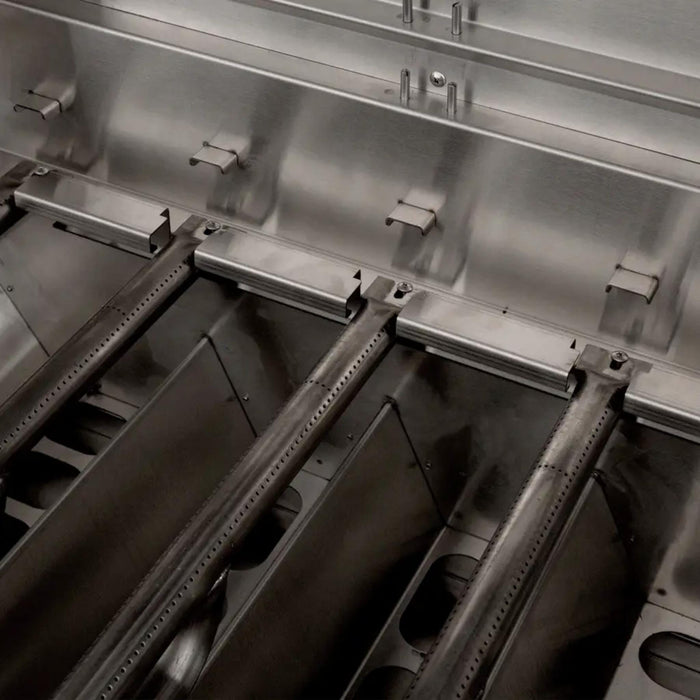 American Made Grills Muscle hybrid grill interior showing heavy-duty stainless steel burners and multi-fuel trays for gas, charcoal, and wood cooking.