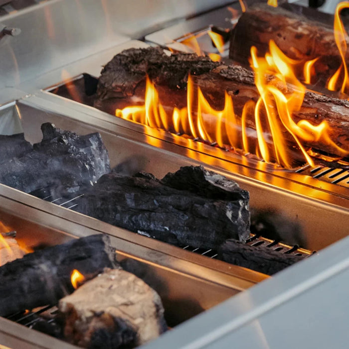 American Made Grills Muscle hybrid grill multi-fuel trays with burning hardwood and charcoal for versatile live-fire outdoor cooking.