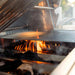American Made Grills Muscle hybrid grill using hardwood and charcoal in multi-fuel trays for authentic live-fire outdoor cooking.