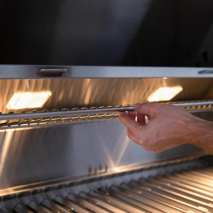 American Made Grills Muscle hybrid grill interior with adjustable warming rack and integrated halogen lights for nighttime grilling.