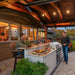 Bromic Platinum Smart-Heat electric radiant heater mounted above a covered outdoor kitchen with built-in gas grill and seating