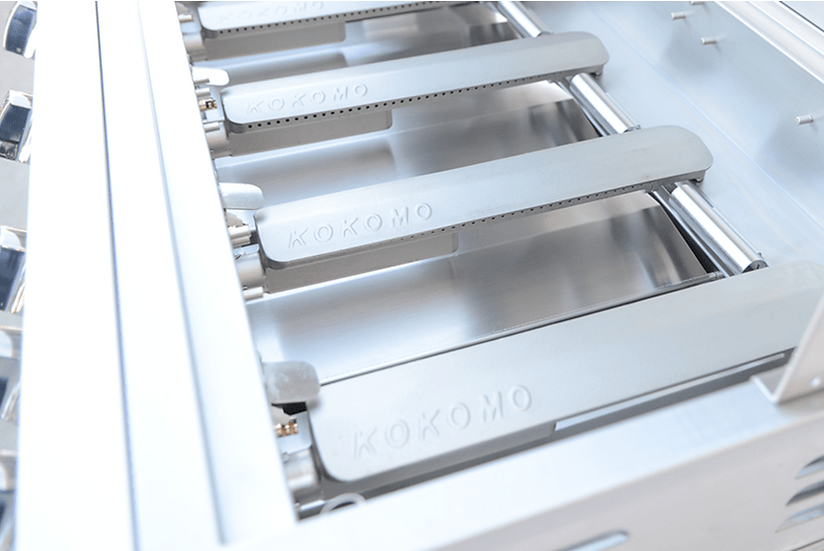 Close-up view of heavy-duty cast stainless steel burners inside a grill, showcasing durable construction and KoKoMo logo