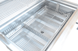 Interior view of a stainless steel charcoal grill showing the adjustable charcoal tray and ventilation slots for precise heat control