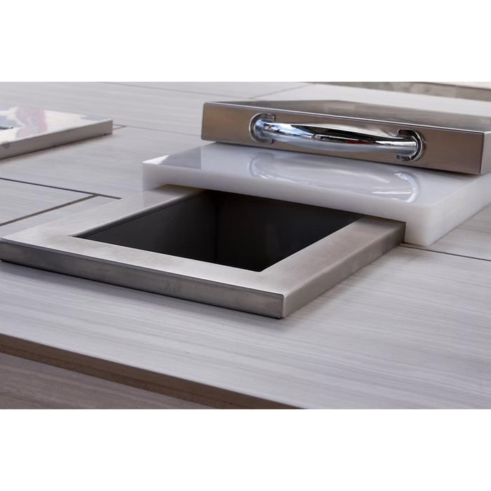 Kokomo Grills built-in stainless steel trash chute installed in an outdoor kitchen countertop with cutting board