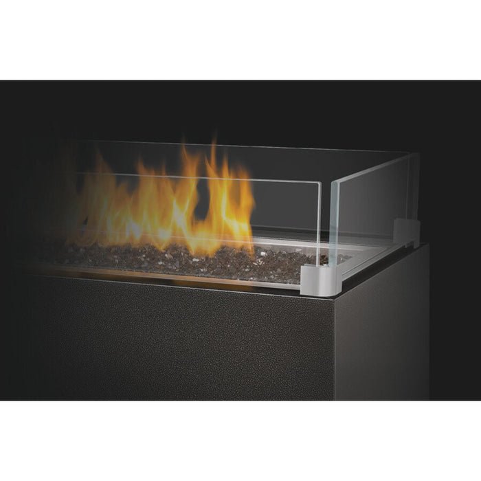 Napoleon linear outdoor gas fire feature with glass windscreen surrounding the burner and decorative glass media