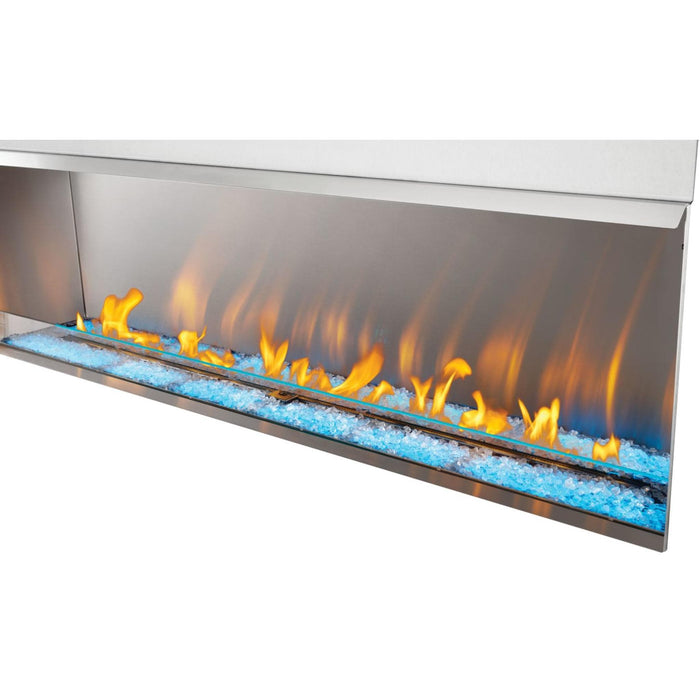Napoleon Galaxy 74-inch outdoor gas fireplace with green LED ember bed lighting, clear glass media, and linear gas flames.