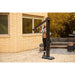 Napoleon Phantom adjustable outdoor electric patio heater being repositioned by a person in a backyard lounge area