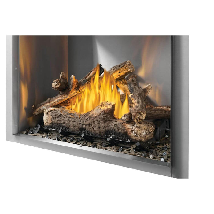 Napoleon Riverside 42-inch natural gas fireplace with oak-style logs, decorative ember media, and polished metal firebox interior.