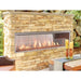 Superior VRE4600 contemporary outdoor vent-free linear gas fireplace installed in a stone patio wall with glass media and flames.