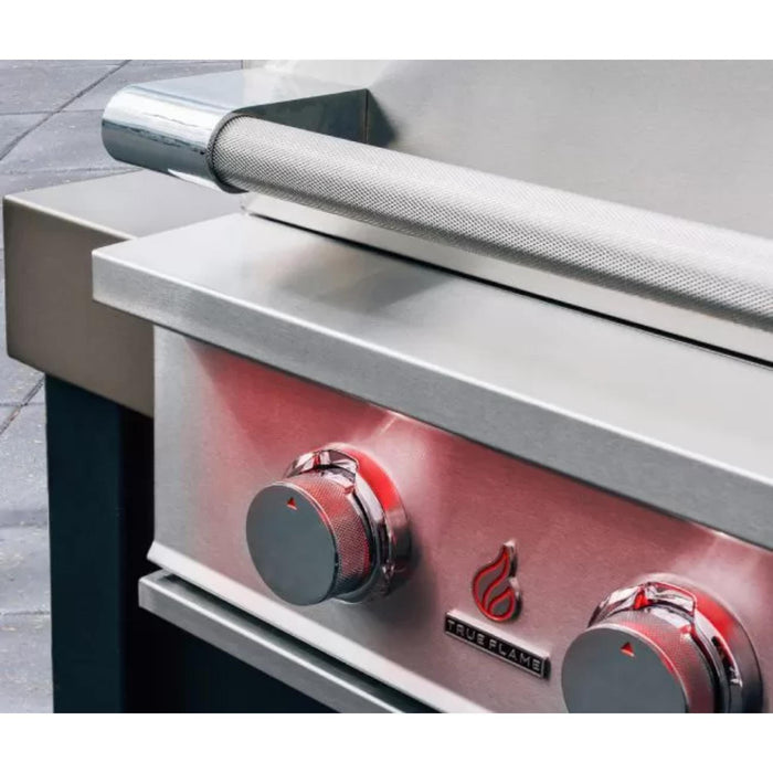 Close-up of TrueFlame built-in gas grill featuring knurled stainless steel hood handle, illuminated burner controls, and TrueFlame logo.