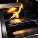 Close-up of TrueFlame built-in gas grill burners and stainless steel flame tamers operating with blue flames.
