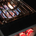 TrueFlame power burner operating with high-output gas flame beneath the removable wok grate and illuminated controls.