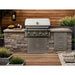 Wildfire Ember 32-inch built-in gas grill installed in a stone outdoor kitchen with stainless steel doors and drawers